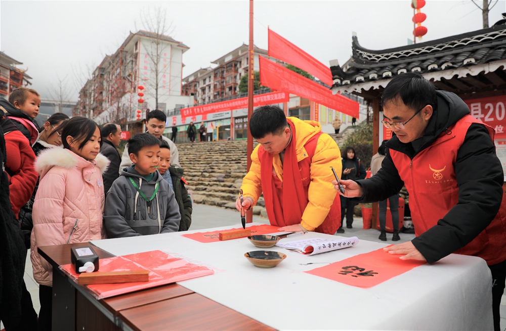 貴州雷山：寫春聯迎新春_fororder_2023年2月2日，在貴州省黔東南苗族侗族自治州雷山縣龍頭街道移民安置點，書法志願者為居民義務寫春聯。 (1)