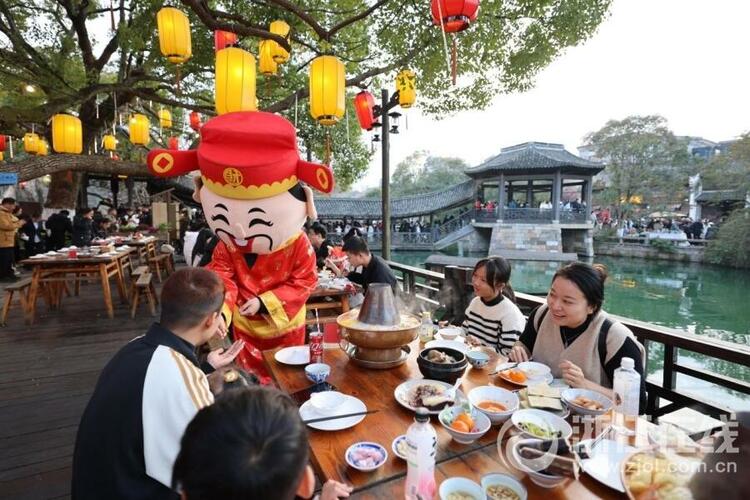 邢然 陆佳钰)2月13日晚,乌镇景区在街巷大摆长街宴,游客边吃着美食,边