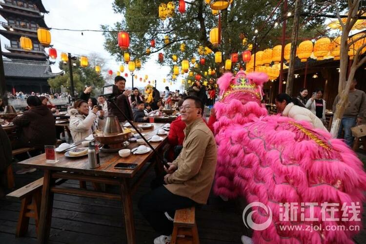 邢然 陆佳钰)2月13日晚,乌镇景区在街巷大摆长街宴,游客边吃着美食,边