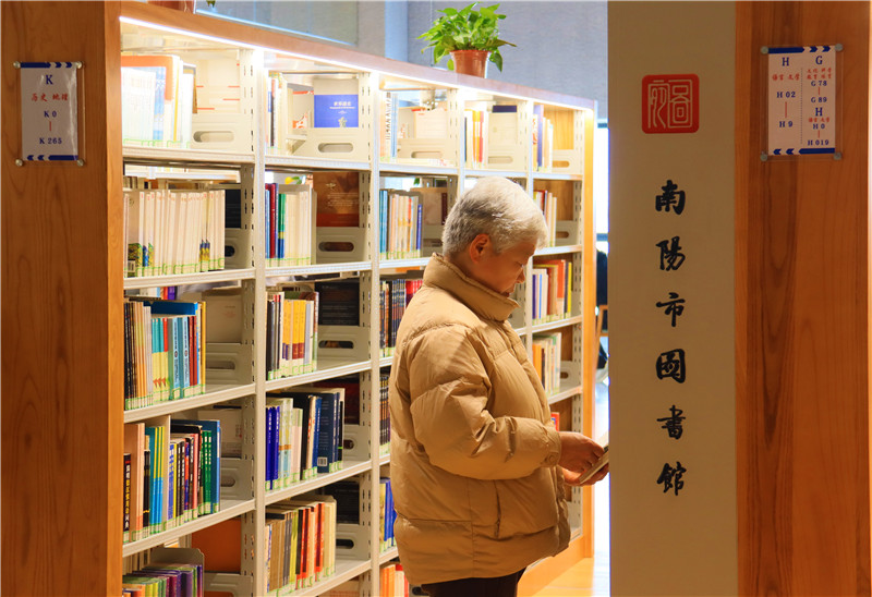 河南南陽：“閱”享新春_fororder_一位老人在圖書館裏選書.JPG