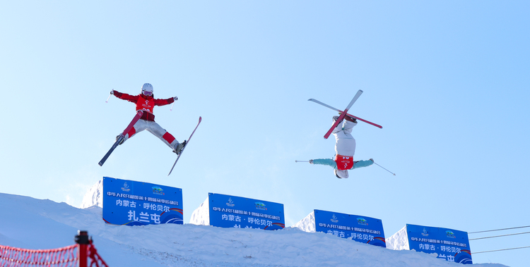 十四冬 赛事_fororder_2月19日，黑龙江选手杨丫（右）在自由式滑雪公开组女子双人雪上技巧决赛中。最终，她夺得冠军。（杨亚东 摄）