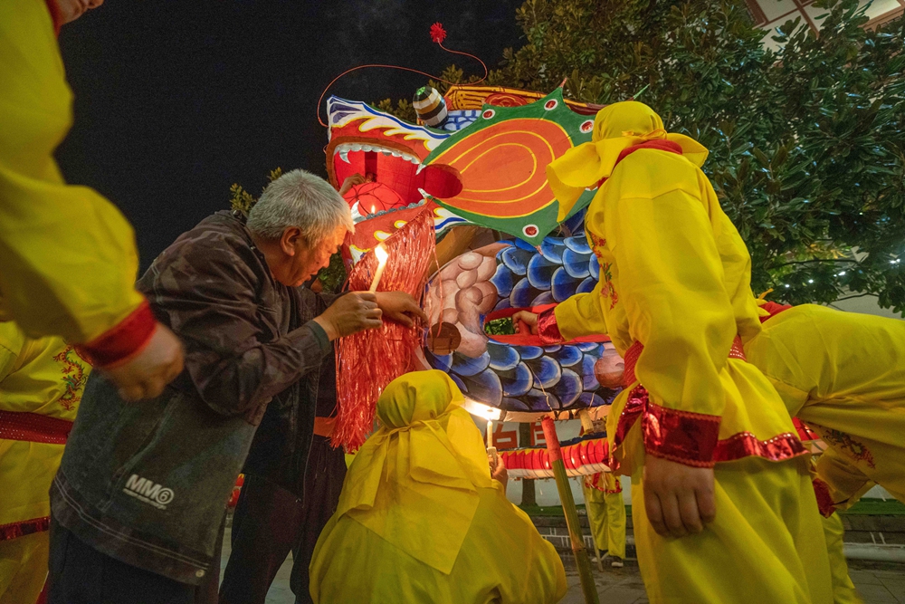 贵州大方：古镇舞龙迎元宵_fororder_2024年2月18日，舞龙队员在贵州省毕节市大方县六龙古镇准备为火龙点上蜡烛。