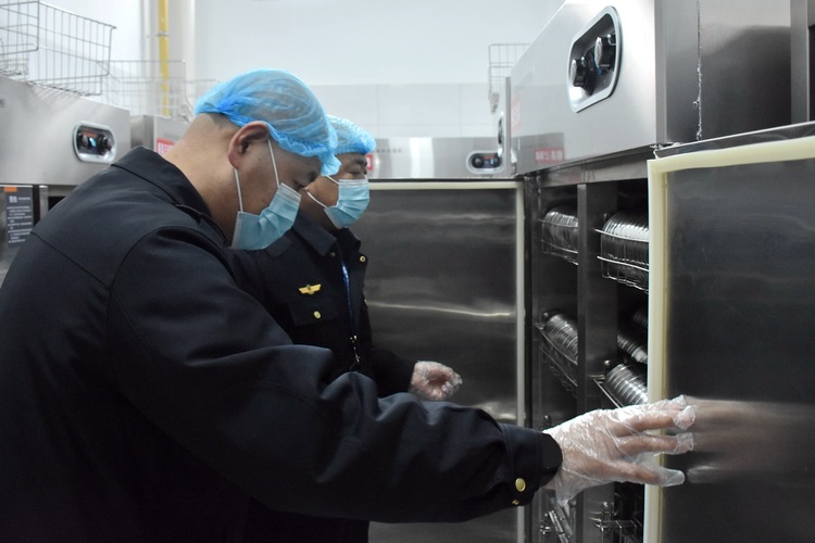 河北清苑：全力守护“开学季”校园食品安全_fororder_执法人员查看校园食堂消毒设备。赵琪摄.JPG