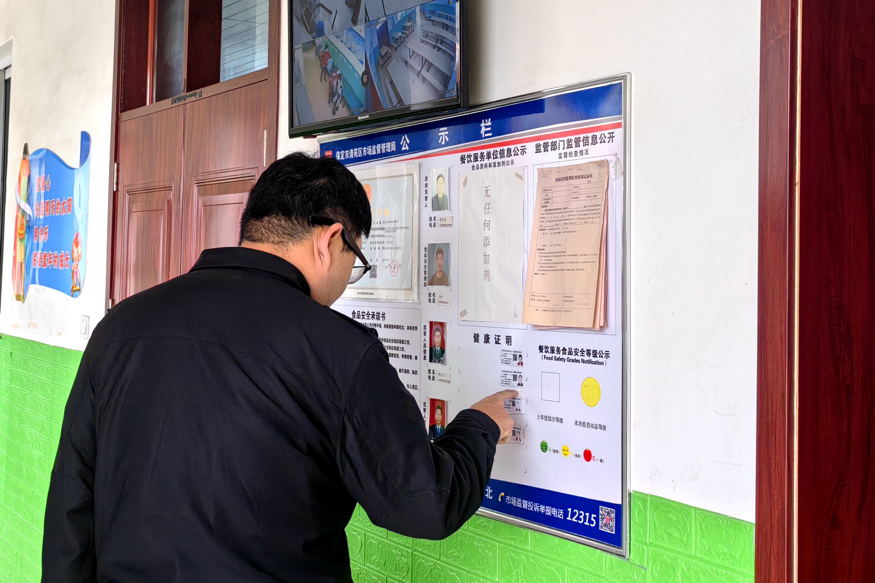 河北清苑：全力守护“开学季”校园食品安全_fororder_执法人员检查餐饮从业人员健康管理情况。赵琪摄