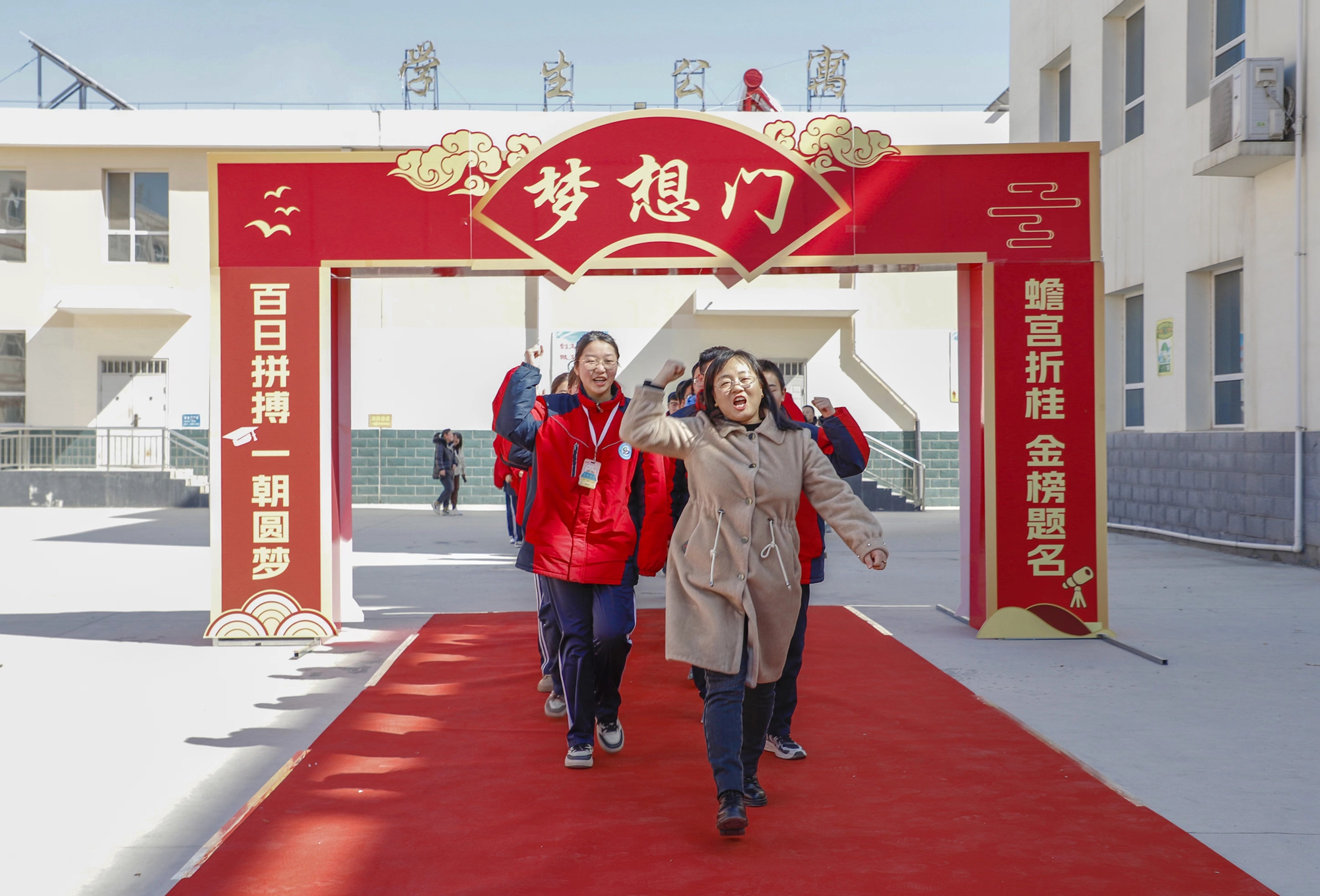 师生集体走过梦想门活动最后,毕业班学生依次踏上红毯,穿过梦想之门