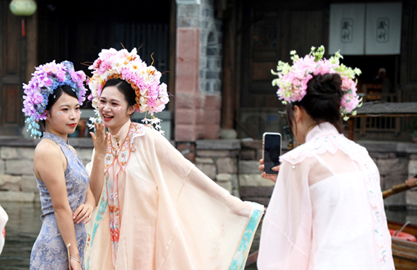 当燃宜宾｜“好玩 好逛 好风景” 宜宾李庄古镇开启“人从众”模式_fororder_游客身着汉服簪花拍照打卡-供图-翠屏区融媒体中心