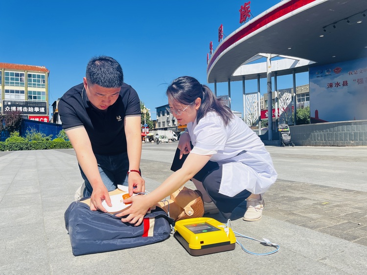 河北涞水：推动AED普及 打造公共场所急救网_fororder_图为专业救护人员指导群众练习使用AED。（李金璐 摄）.JPG