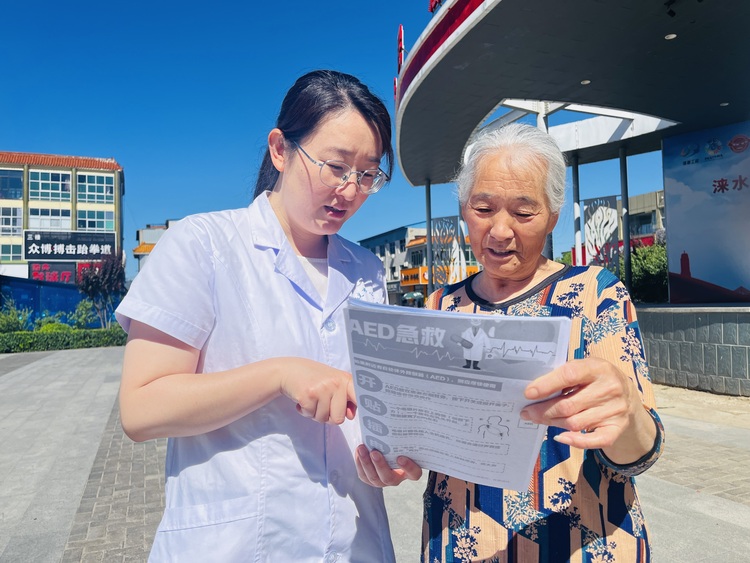 河北涞水：推动AED普及 打造公共场所急救网_fororder_图为专业救护人员向群众发放AED使用明白纸。（李金璐 摄）.JPG