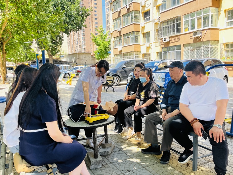 河北涞水：推动AED普及 打造公共场所急救网_fororder_图为在涞水县泰安路社区，专业救护人员向居民讲解AED的使用方法。（李金璐 摄）.JPG