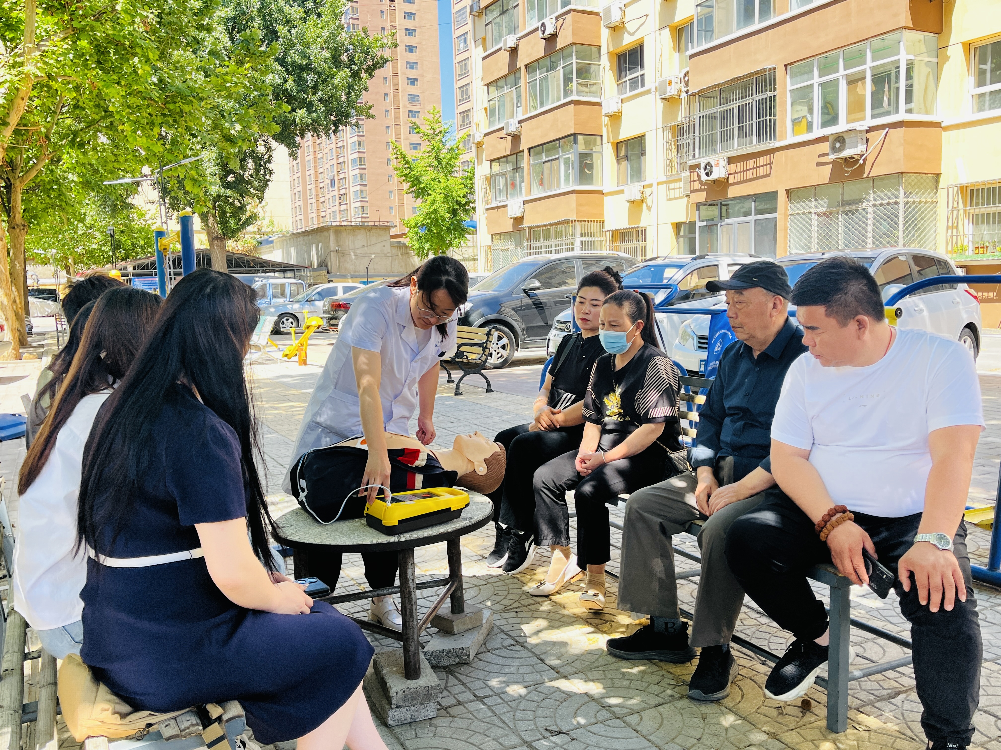 河北淶水:推動AED普及 打造公共場所急救網_fororder_圖為在淶水縣泰安路社區,專業救護人員向居民講解AED的使用方法。(李金璐 攝).JPG