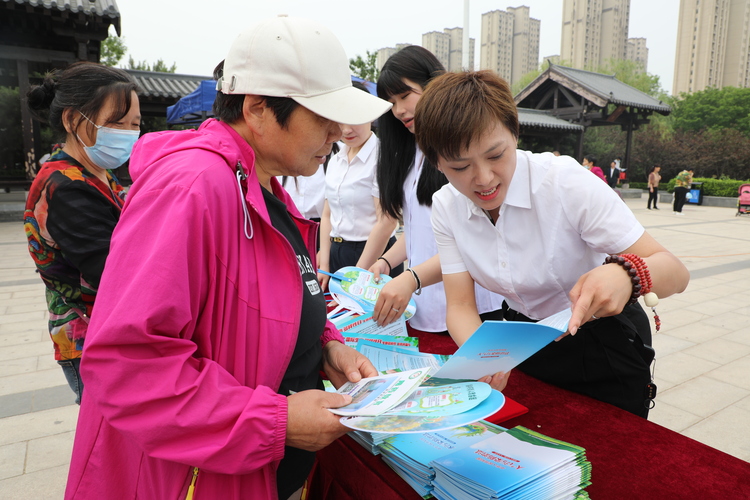 河北涞水：保护生物多样性 共同守护绿色家园_fororder_图为工作人员向群众讲解保护生物多样性的宣传手册。（徐梓钰 摄）.JPG