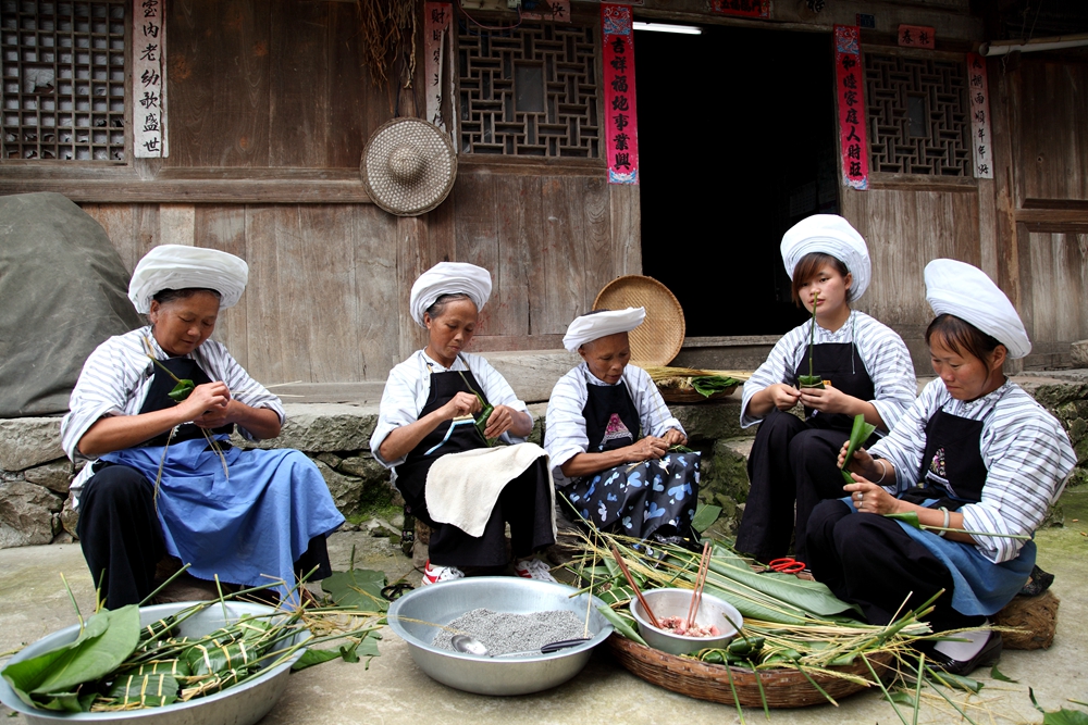 鲜花洗眼 吃美味灰粽 到“中国糯食之乡”贵州贞丰感受特色端午民俗_fororder_布依族包粽子  王诚摄.JPG