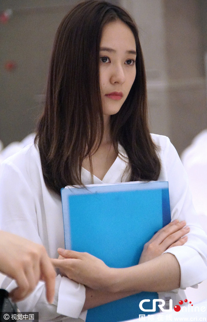 郑秀晶拍戏双手交叉护胸添帅气 抿嘴甜笑显羞涩