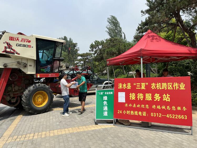 河北淶水：搶抓農時推進“三夏”生産_fororder_圖為工作人員為跨區作業農機手送上防暑物資。（徐梓鈺 攝）