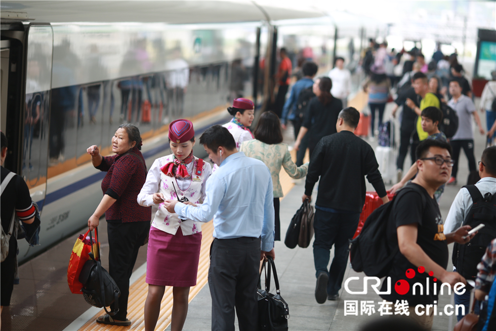 圖片默認標題_fororder_在重慶北站北廣場站臺上，郭莉為旅客解答問題。