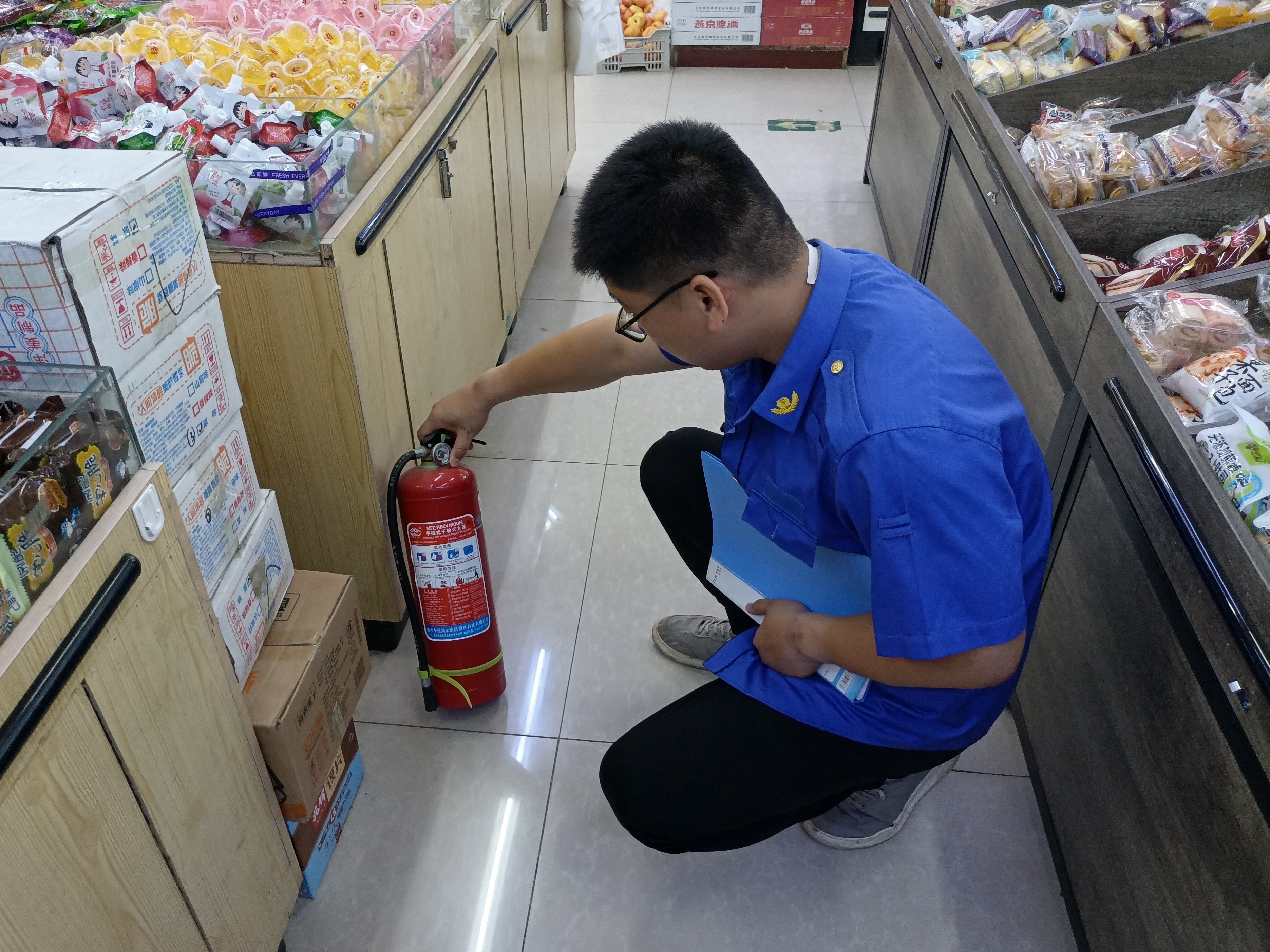 河北唐县：多措并举筑牢安全生产防线_fororder_工作人员在超市检查灭火器