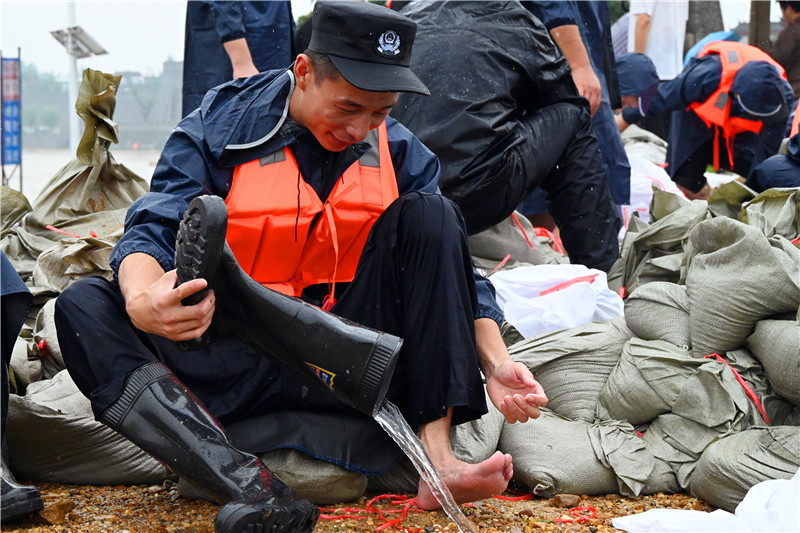 南阳市社旗县：众志成城防大汛_fororder_抢险人员倒出胶鞋中的积水 摄影 申鸿皓