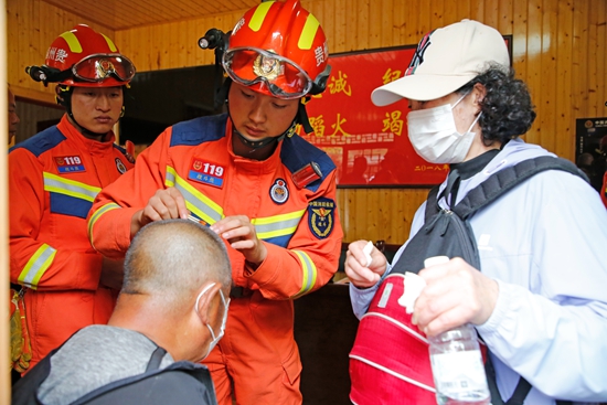 貴州安順黃果樹：消防員為景區安全旅遊保駕護航_fororder_消防員在執勤點幫助受傷遊客.JPG