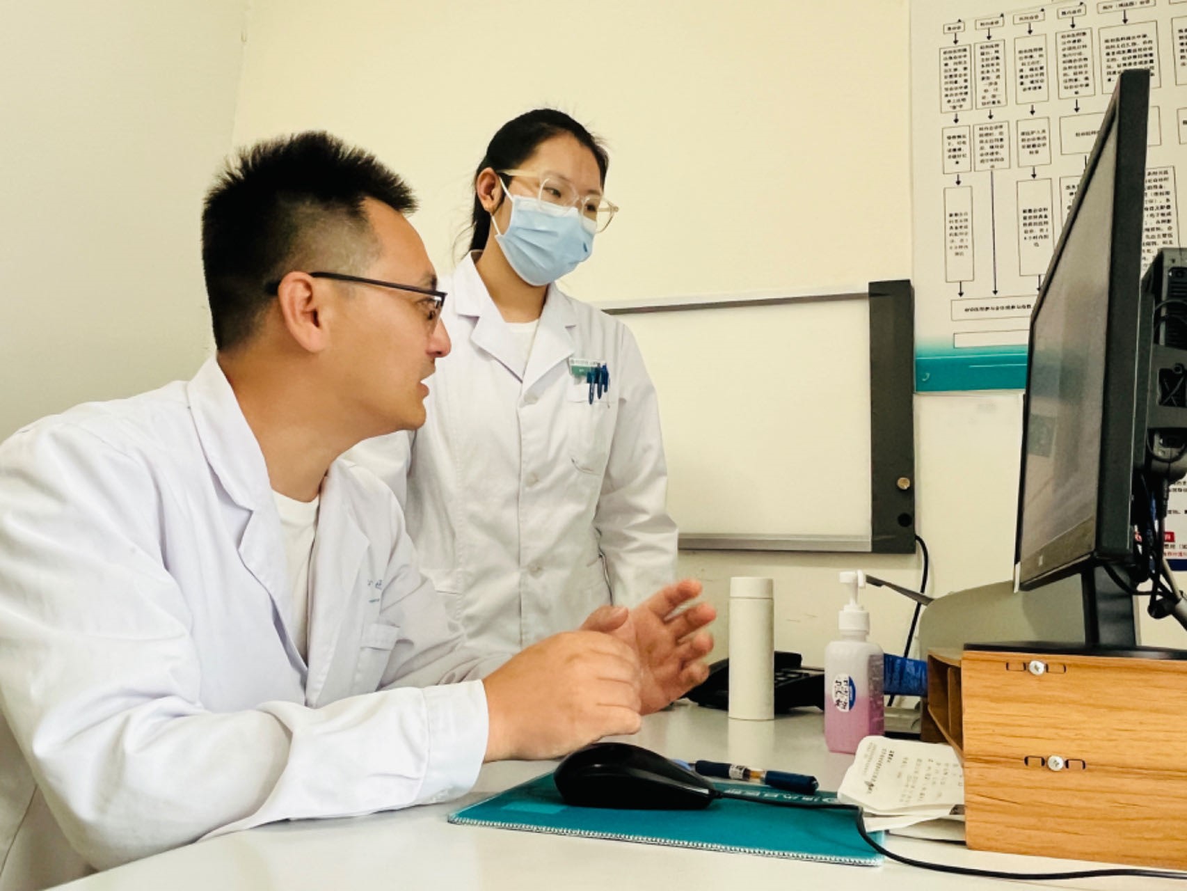 河北涞水：京冀专家坐诊 精准“把脉”促提升_fororder_图为保定市第一中心医院派驻医生正在与涞水县医院医生共同研判患者病情。（徐梓钰 摄）