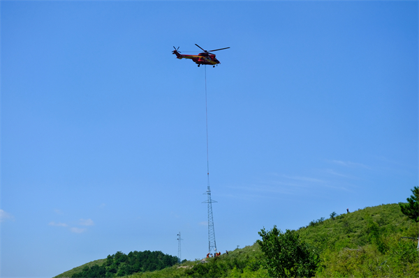 空地精準對接組立新塔！國家電網直升機助力主網復電_fororder_8月27日，國網遼寧電力聯合國網空間技術公司，使用直升機採取“拆舊+立新”模式，在33號原塔基組立新塔。地面人員配合調整鐵塔方位。牟超 攝_副本