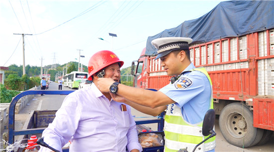 南阳市西峡县：护航致富路 平安庆丰收_fororder_西峡交警为驾驶员佩戴安全头盔 摄影 丁俊良