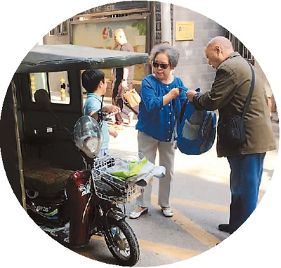 5月10日,北京市朝阳区某小学放学后,2名随迁老人骑着三轮车接孩子.