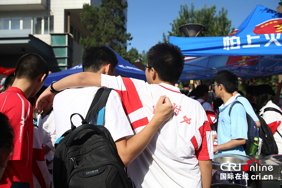 两名考生在考场外相互搭肩,给好兄弟加油