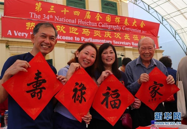 1月15日,书法爱好者在新加坡举行的第34届全国挥春大会上展示书法作品。新华社记者包雪琳摄