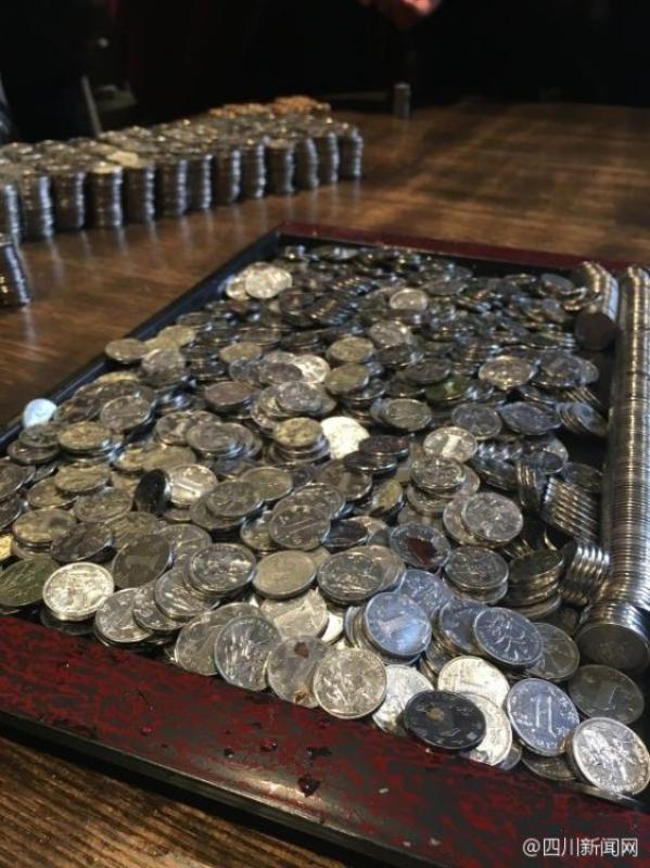成都宽窄巷硬币池捞钱 满桌硬币密密麻麻