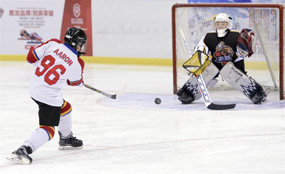 2月13日,北京市零度阳光火龙冰球队球员魏子尧(左)在比赛中射门.