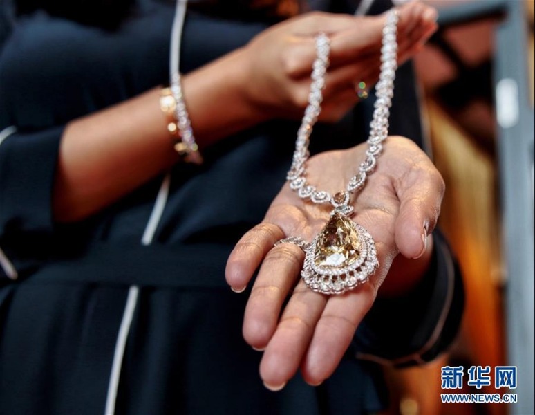 3月2日，一家香港珠宝公司职员向记者展示钻石总重量为97.03克拉的梨形黄钻项链。 新华社发（王玺摄）