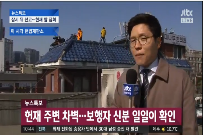 记者爬上屋顶拍摄