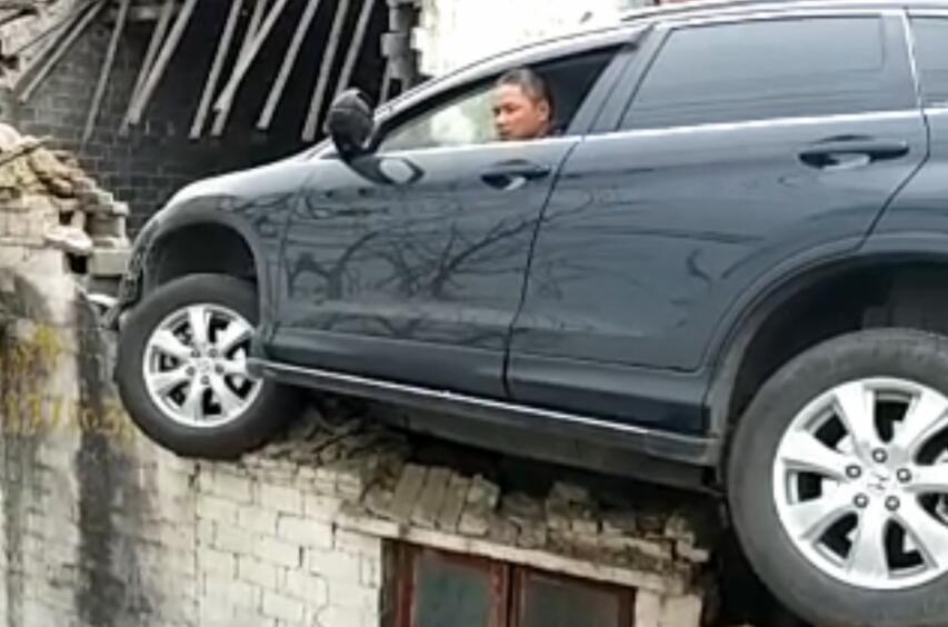 江苏离奇交通事故汽车飞上屋顶 司机被困一脸懵