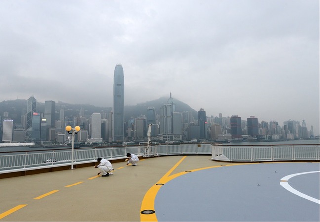 3月22日,在香港维多利亚港,工作人员在丽星邮轮“处女星号”的甲板上忙碌。新华社记者 刘昀 摄