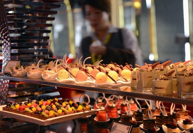 3月22日,在香港维多利亚港,游客在丽星邮轮“处女星号”上享用美食。新华社记者 刘昀 摄