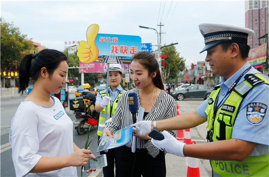 陕西渭南志愿者街头举牌呼吁“车让我  我快走 ”