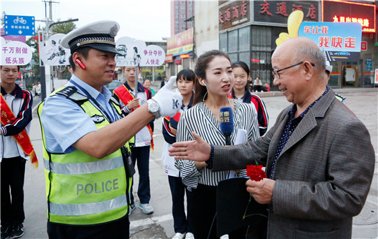 陕西渭南志愿者街头举牌呼吁“车让我  我快走 ”