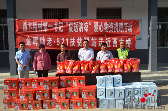 李运东（右二）组织阳光志愿者给贫困户捐赠现场