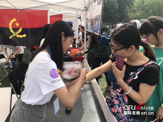 学生在游客手臂上画国旗