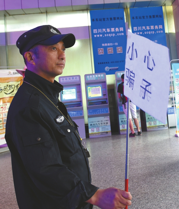 成都五块石车站保安扛旗巡逻提醒旅客小心骗子