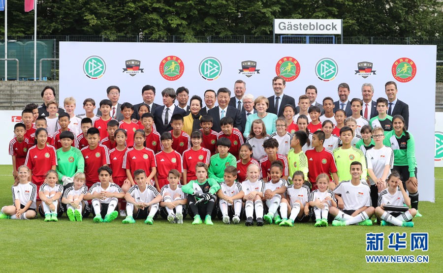 7月5日，国家主席习近平在柏林同德国总理默克尔共同观看中德青少年足球友谊赛。这是习近平和夫人彭丽媛同默克尔与双方小球员合影。新华社记者 王晔 摄