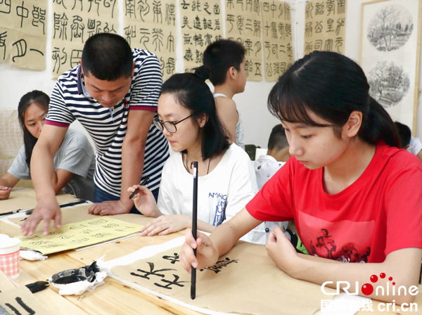 广安华蓥:书法家教留守学生学习毛笔书法