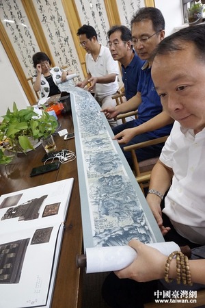 参会人员欣赏魏滔老人的《山海经》长卷工笔画作艺术。(中国台湾网记者 杨旋 摄)