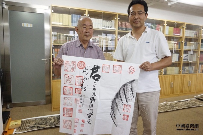 台湾古文物收藏家协会会长黄启和向北京大学文化研究与发展中心教授王德元赠字并合影。(中国台湾网记者 杨旋 摄)