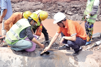 【社会民生】重庆石杨路水管被挖破 工人抢修像做外科手术