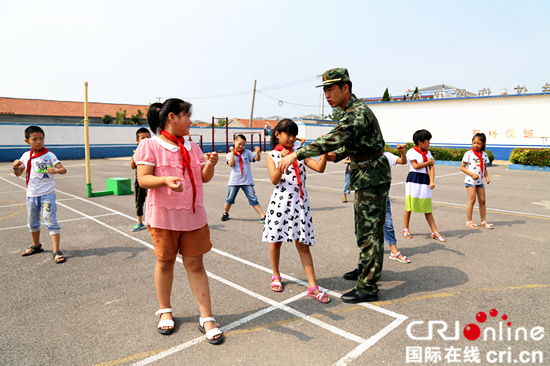 濱州邊防派出所帶領留守兒童體驗警營生活_fororder_官兵在指導留守兒童練擒敵拳.JPG